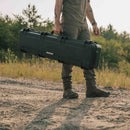 Man holding a Nanuk 994 rifle case in the outdoors.